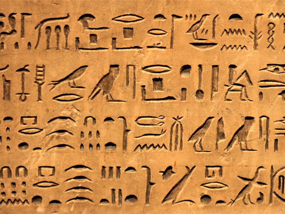 Ancient scribe writing on parchment with quill